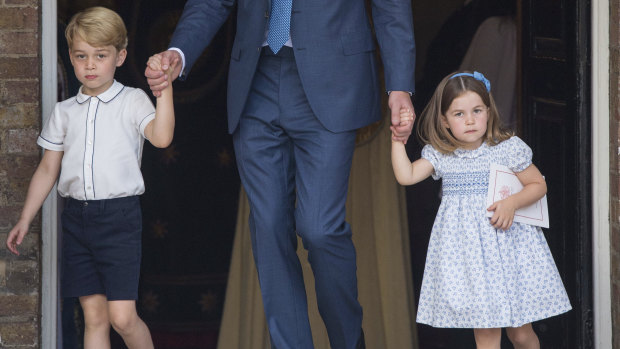 Prince George and Princess Charlotte holding onto their father Prince William's hands as they leave the chapel.