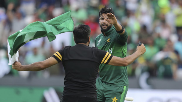 A fan runs onto the field to congratulate Imad Wasim.