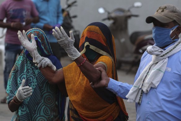 A relative of a patient who died of COVID-19 mourns outside a hospital in Ahmedabad in India on Tuesday.