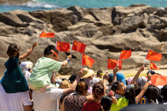 Tourists wave Chinese national flags on the Qishuiwan Beach in Wenchang.