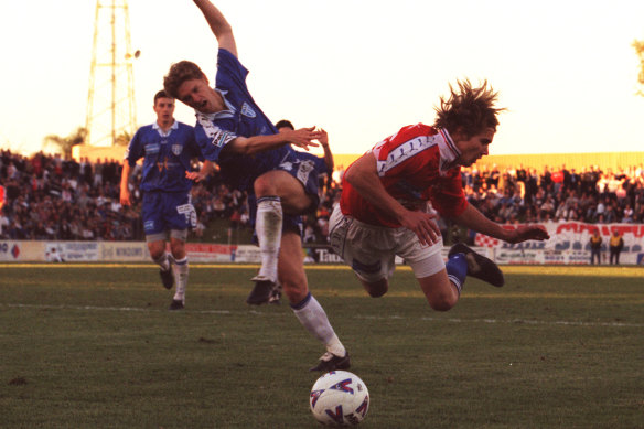Joel Griffiths is sent flying during a 1999 NSL match between South Melbourne and Sydney United.