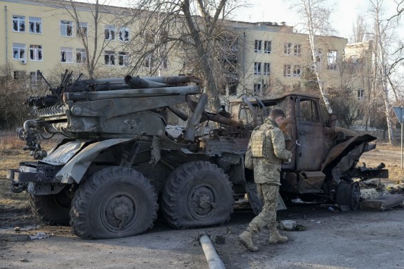 A Ukrainian soldier passes by a destroyed Russian artillery system “Grad”, in Kharkiv on March 24.