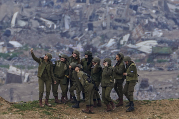 Israeli female soldiers pose for a photo on a position on the Gaza Strip border, in southern Israel.