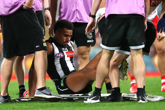 Isaac Quaynor is helped from the field after suffering a serious cut to his leg.