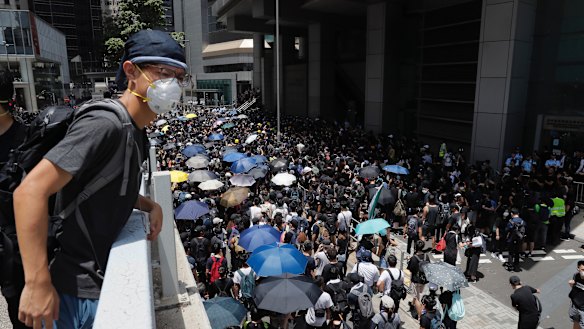 Protesters surround the police headquarters in Hong Kong on Friday.