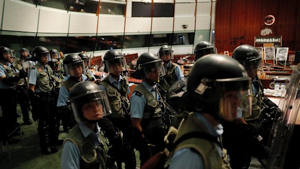 Police officers with protective gear retake the meeting hall of the Legislative Council in Hong Kong early on Tuesday.