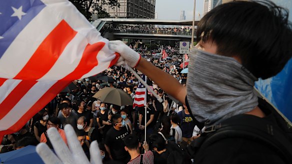 A protester waves a US flag on the streets of Hong Kong. 