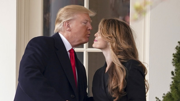 US President Donald Trump kisses White House communications director Hope Hicks on her last day on Friday.