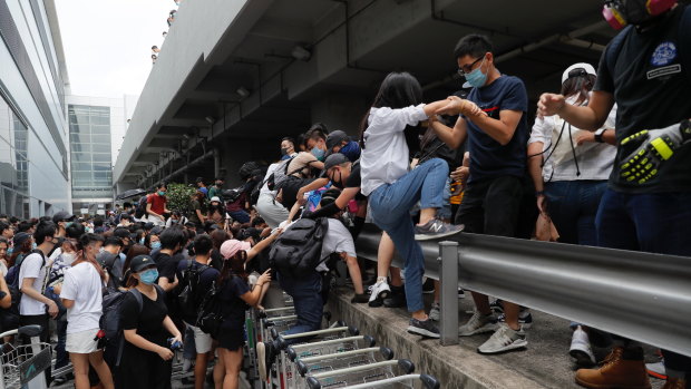 Pro-democracy protesters leave after riot police arrive outside the airport in Hong Kong.
