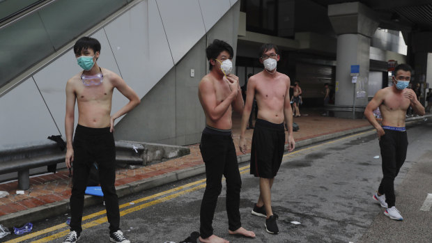 Protesters remove their shirts and try to wash their bodies after being pepper sprayed by police during protests in Hong Kong.
