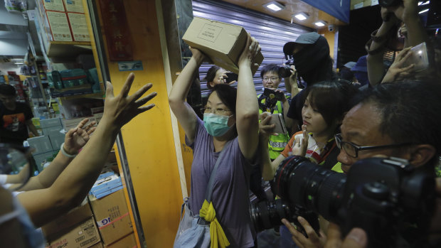 A protester throws a box of goods at a store that sells to mainland customers in Hong Kong.  