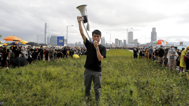 Hong Kong pro-democracy lawmaker Roy Kwong speaks over a loud hailer to the police as he joins protesters on July 1.
