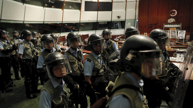 Police officers with protective gear retake the meeting hall of the Legislative Council in Hong Kong early on Tuesday.