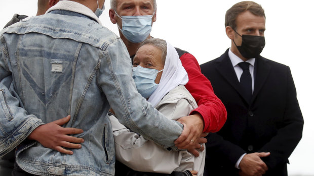 France President Emmanuel Macron (right) stands as Sophie Petronin (centre), a French aid worker who held hostages for four years by Islamic extremists in Mali, is greeted by relatives upon her arrival at the Villacoublay military airport near Paris.