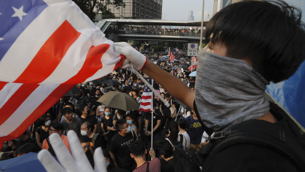 A protester waves a US flag on the streets of Hong Kong. 