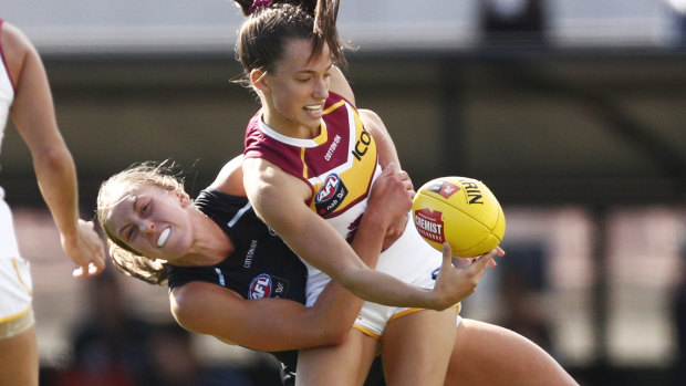 Charlotte's web: Brisbane's Jade Ellenger is caught up in a tackle by Blues' Charlotte Wilson.