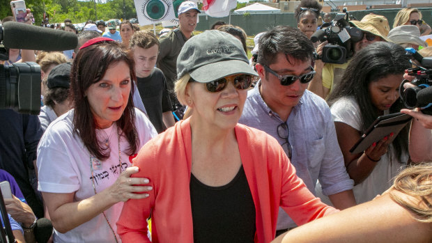 Democratic presidential candidate Senator Elizabeth Warren is swarmed by the media while walking past the Homestead Detention Centre, where the US is detaining migrant teens, in Homestead, Florida. 
