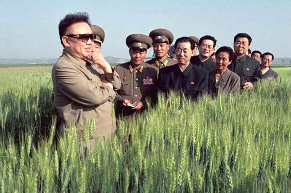 North Korea's then leader Kim Jong-il, left,  visits a farm with officials in 2003.