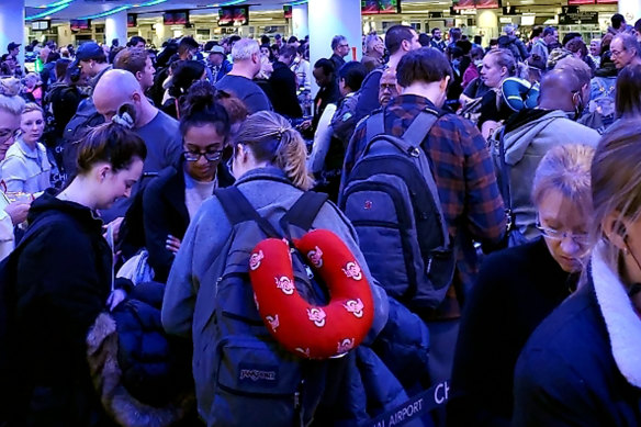 Travellers returning from Madrid wait in a coronavirus screening line at Chicago's O'Hare International Airport.