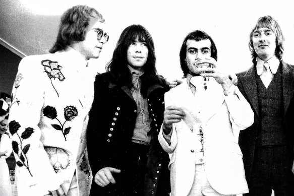 The suit that became Bernie Taupin’s sartorial malfunction while bowing to Princess Margaret. With, from left, Elton John, drummer Nigel Olsson and bassist Dee Murray (far right).