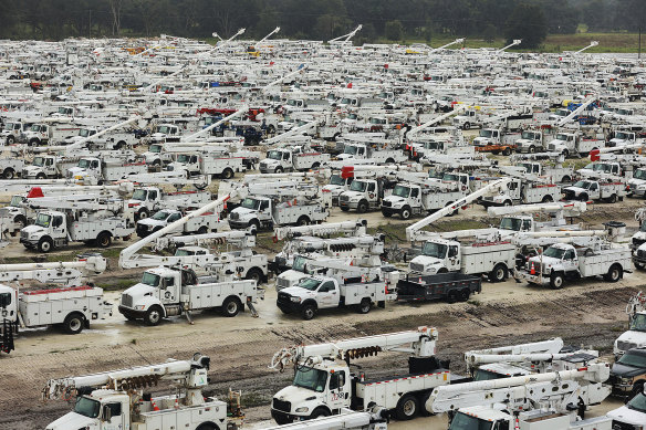 Trucks and utilities are staged in a rural lot in Sumter County, Florida, as part of emergency preparations.