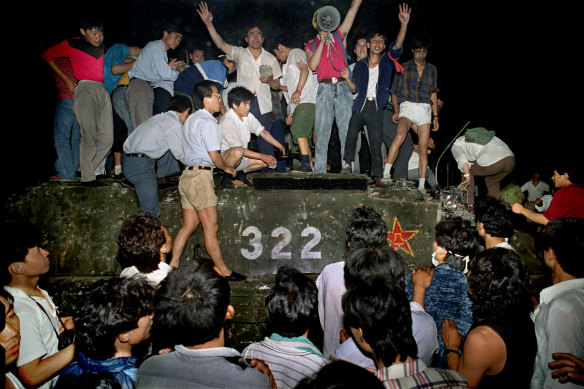 Civilians stand on a government armoured vehicle in Beijing on June 4, 1989.