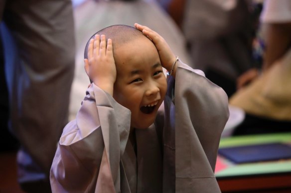 A boy, whose Buddhist name is Da Sun, touches his newly shaved head during a service to have an experience of the lives of Buddhist monks, at the Jogye Temple in Seoul, South Korea.  Children will now have the day they were born registered as their official birthday.