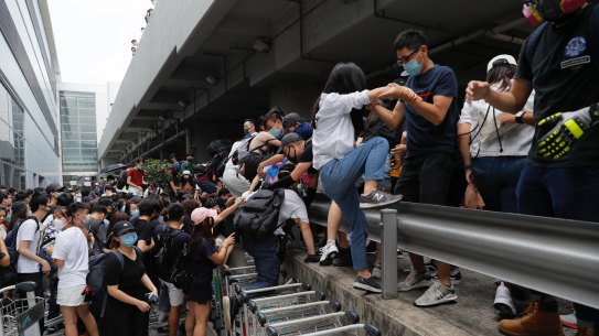 Pro-democracy protesters leave after riot police arrive outside the airport in Hong Kong.