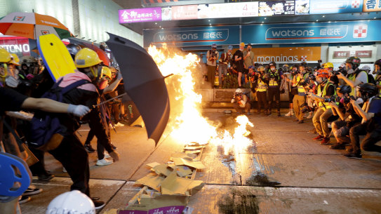 Protesters burn cardboard to form a barrier as they confront with police in Hong Kong.