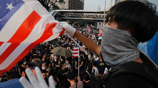 A protestor waves a US flag on the streets of Hong Kong. 