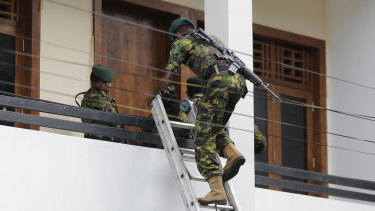 Sri Lankan police commandos enter a suspected hideout of militants following a shootout in Colombo. 