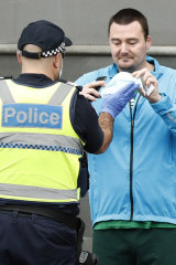 A man is confronted by a police officer at the anti-lockdown protest.