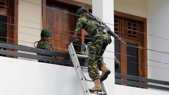 Sri Lankan police commandos enter a suspected hideout of militants following a shootout in Colombo. 