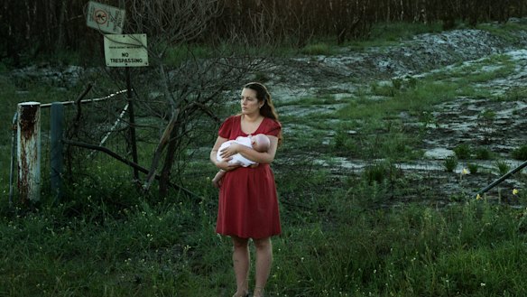 Samantha Kelly with her baby William near one of the contaminated drains near RAAF base Williamtown. 