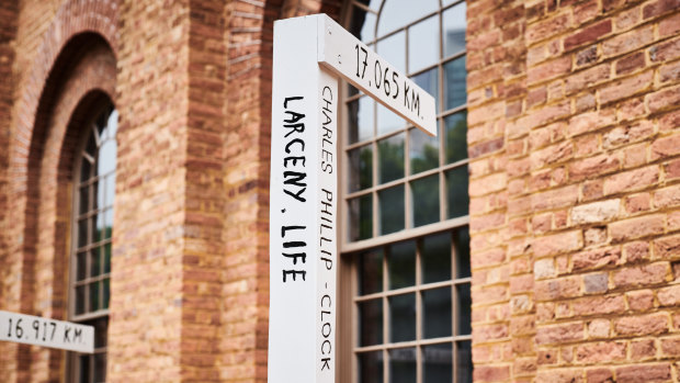 The signposts resemble street signs and point in the exact direction of convicts and migrants’ homes.
