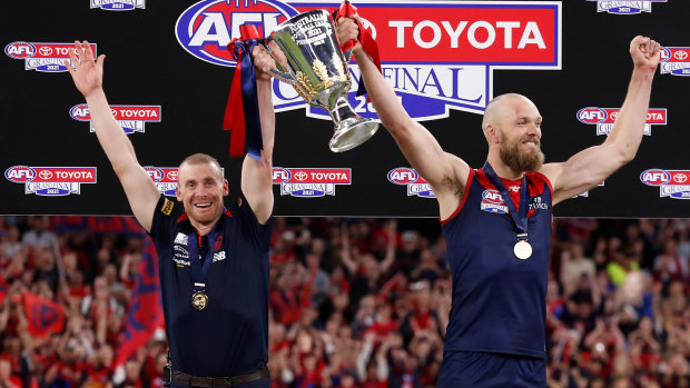 Melbourne coach Simon Goodwin and captain Max Gawn stand euphorically with premiership cup in-hand.