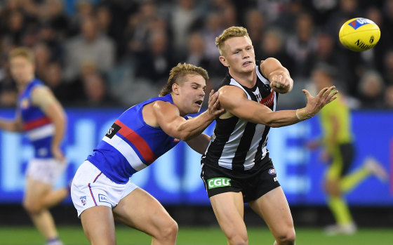 Adam Treloar passes the ball for the Magpies.