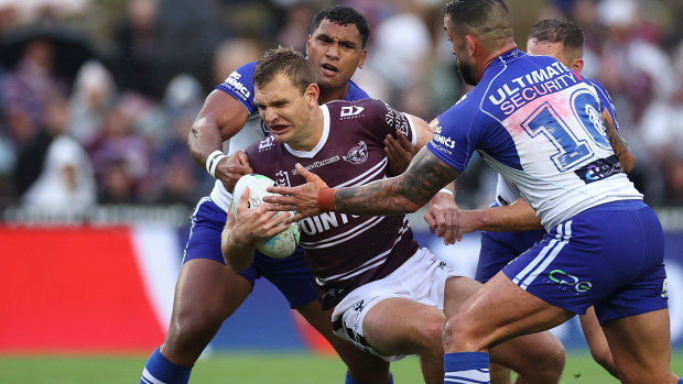 Manly fullback Tom Trbojevic tries to wrestle past the Bulldogs defence on the night of the opening of the Bob Fulton Stand.