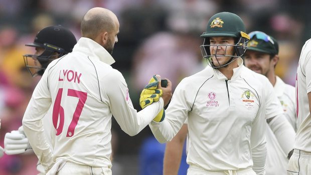 Nathan Lyon is congratulated by Tim Paine after taking five wickets at the SCG on Sunday. 
