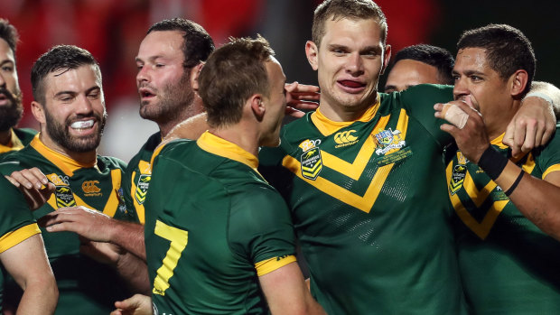 Passion play: The Kangaroos mob Tom Trbojevic after adding to the visitors' tally.