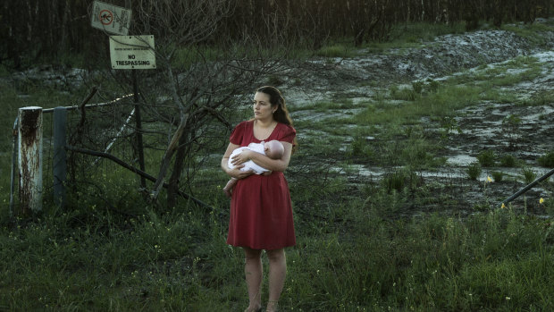 Samantha Kelly with her baby William near one of the contaminated drains near RAAF base Williamtown. 