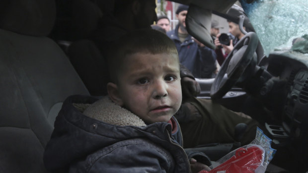 A boy cries in a damaged car after government air strikes in the town of Ariha in Idlib province, Syria.