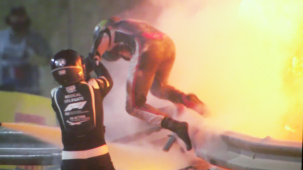 Romain Grosjean is helped from his burning car. 