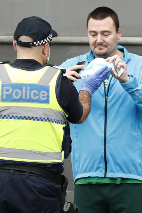 A man is confronted by a police officer at the anti-lockdown protest.