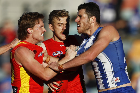 Gold Coast pair Noah Anderson and Hugh Greenwood remonstrate with North Melbourne’s Tristan Xerri.