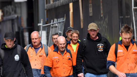 Knock off time- Construction workers leave a city building site. 24th March 2020 The Age news Picture by Joe Armao