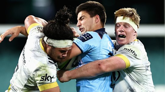 Jack Madocks gets wrapped up by the Hurricanes defence.