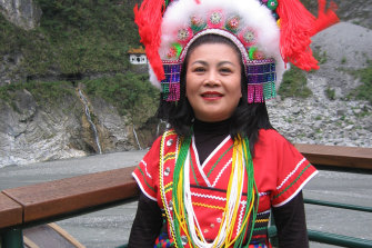 An Atayal woman in traditional costume stands in front of the Liwu River which runs through the Taroko Gorge in Taiwan.