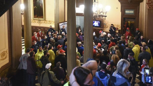 People protest outside the entrance of the Michigan House of Representatives in Lansing, Michigan. 