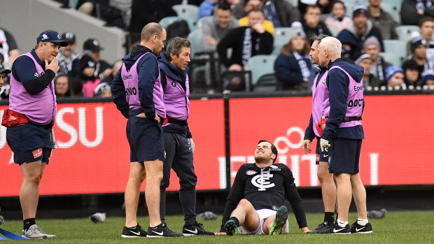 Crocked: Carlton's Lachie Plowman receives attention after sustaining an injury during the round 14 clash against Collingwood.